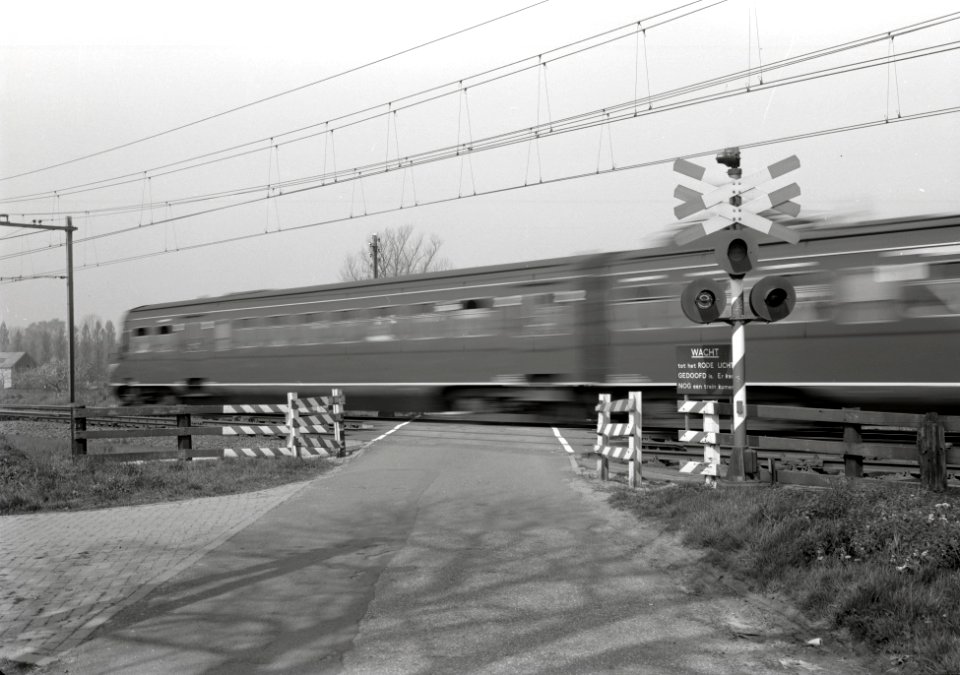 HUA-167627-Afbeelding van een voorbij rijdende trein op de spoorwegovergang in de spoorlijn Utrecht-Amersfoort in de Voordorpsedijk bij Blauwkapel