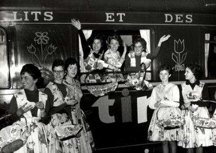 HUA-168309-Groepsportret van de gastvrouwen van de Tintentuintrein te Rotterdam, met in het midden TV-omroepster Karin Kraaykamp. N.B. De Tintentuintrein was een promotietrein van de groothandel in woningtextiel