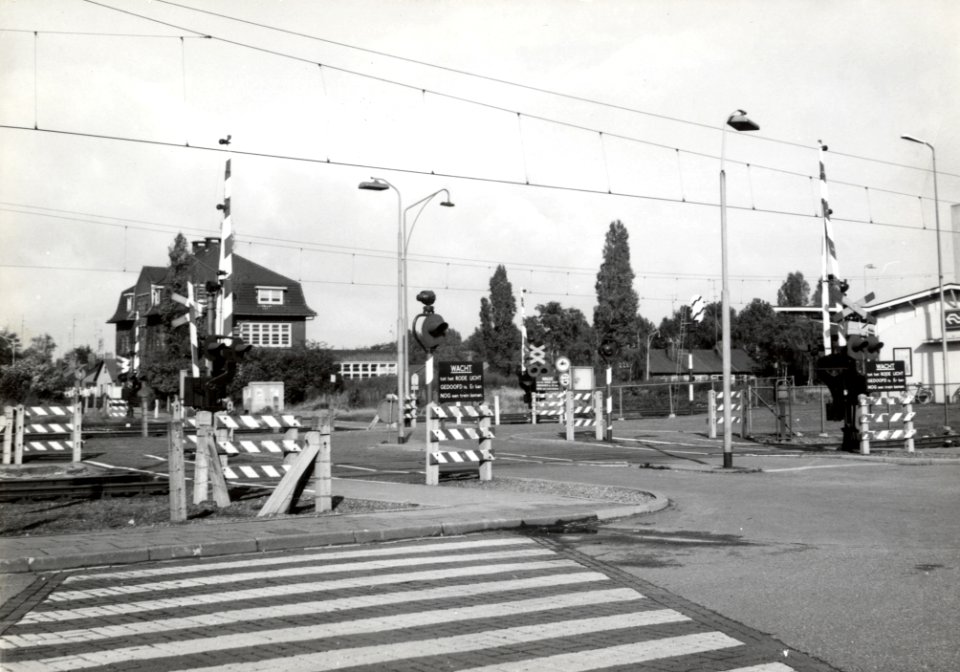 HUA-169432-Gezicht op de spoorwegovergang in de Houtmanstraat te Geleen. Rechts een deel van het N.S.-station Geleen-Lutterade