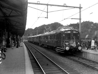 HUA-167860-Afbeelding van de feesttrein (een versierd electrisch treinstel bestaande uit rijtuigen mat. 1924, "Blokkendozen" van de N.S) langs het perron van het N.S.-station Baarn te Baarn, ter gelegenheid van 