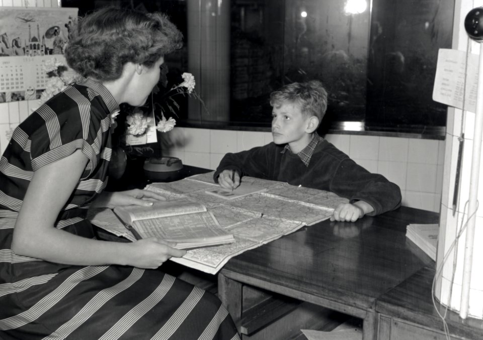 HUA-168010-Afbeelding van de 9-jarige Maarten van Traa uit Groningen en een informatrice van de Nederlandse Spoorwegen in het Inlichtingenbureau van de N.S. in het N.S.-station Utrecht C.S. te Utrecht. N.B. Maar