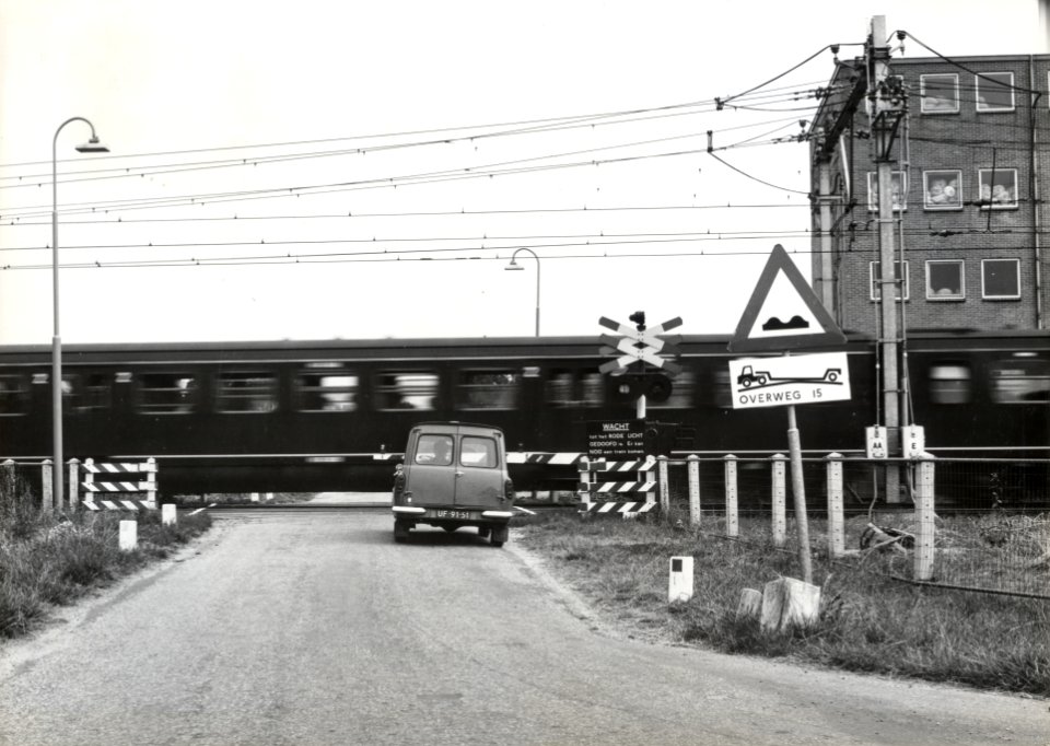 HUA-169451-Gezicht op de spoorwegovergang in de Vlierweg Odijkseweg te Houten met een passerende trein