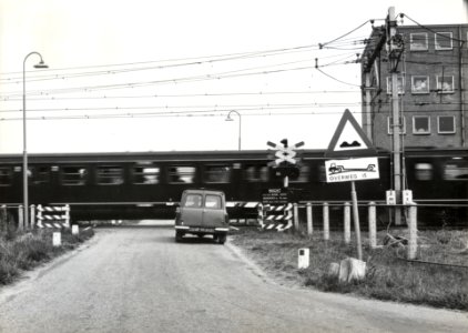 HUA-169451-Gezicht op de spoorwegovergang in de Vlierweg Odijkseweg te Houten met een passerende trein