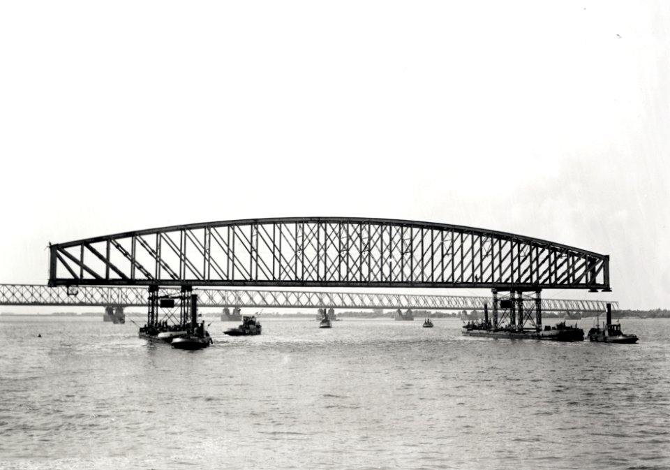 HUA-167982-Afbeelding van het uitvaren van een oud brugdeel van de spoorbrug over het Hollands Diep (Moerdijkbrug) bij Moerdijk. Op achtergrond de verkeersbrug