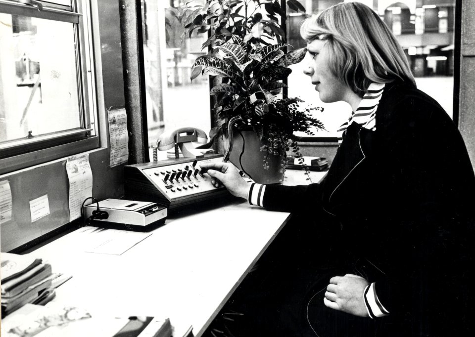 HUA-169313-Afbeelding van een informatrice met telecominstallatie in de hal van het N.S.-station Den Haag C.S. te Den Haag