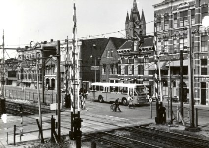 HUA-169389-Gezicht op de spoorwegovergang tussen de Spoorsingel en de Phoenixstraat (achtergrond) te Delft, met een autobus van de N.V. Westlandsche Stoomtramweg Maatschappij