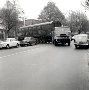 HUA-168095-Afbeelding van het vervoer van een goederenwagen van de NS op een oplegger van een vrachtauto wagon trailer of rolwagenvervoer te Eindhoven