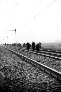 HUA-165757-Afbeelding van de werkzaamheden ten behoeve van de baanverzwaring tussen Amsterdam en Utrecht, ter hoogte van Duivendrecht, met een ploeg wegwerkers die een spoorstaaf gaan verplaatsen