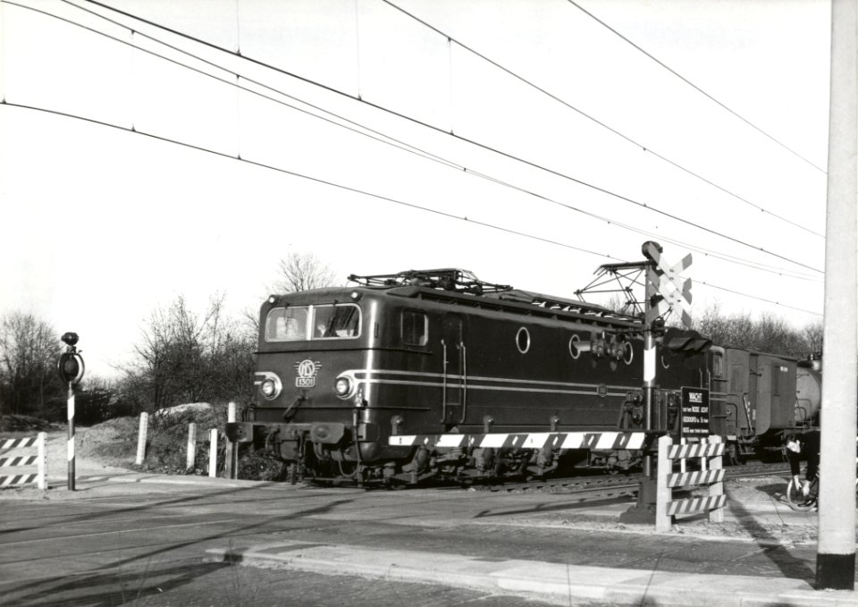 HUA-169416-Afbeelding van de electrische locomotief nr. 1301 (serie 1300) van de N.S. met een goederentrein op de spoorwegovergang in de Barchman Wuytierslaan te Amersfoort