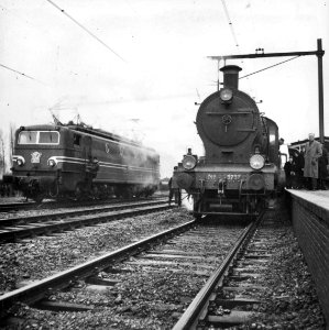 HUA-153442-Afbeelding van de stoomlocomotief nr. 3737 (serie 3701-3815) van de N.S. tijdens haar laatste rit met links de electrische locomotief nr. 1301 (serie 1300) van de N.S. op het N.S.-station Geldermalsen