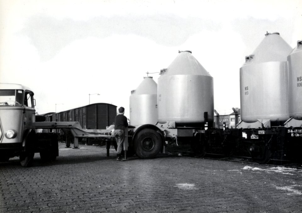 HUA-169594-Afbeelding van het overladen van een silolaadkist voor het vervoer van soda van trein naar vrachtwagen op de laad- en losplaats van het N.S.-station Schiedam