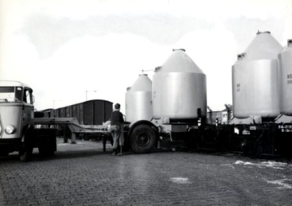 HUA-169594-Afbeelding van het overladen van een silolaadkist voor het vervoer van soda van trein naar vrachtwagen op de laad- en losplaats van het N.S.-station Schiedam