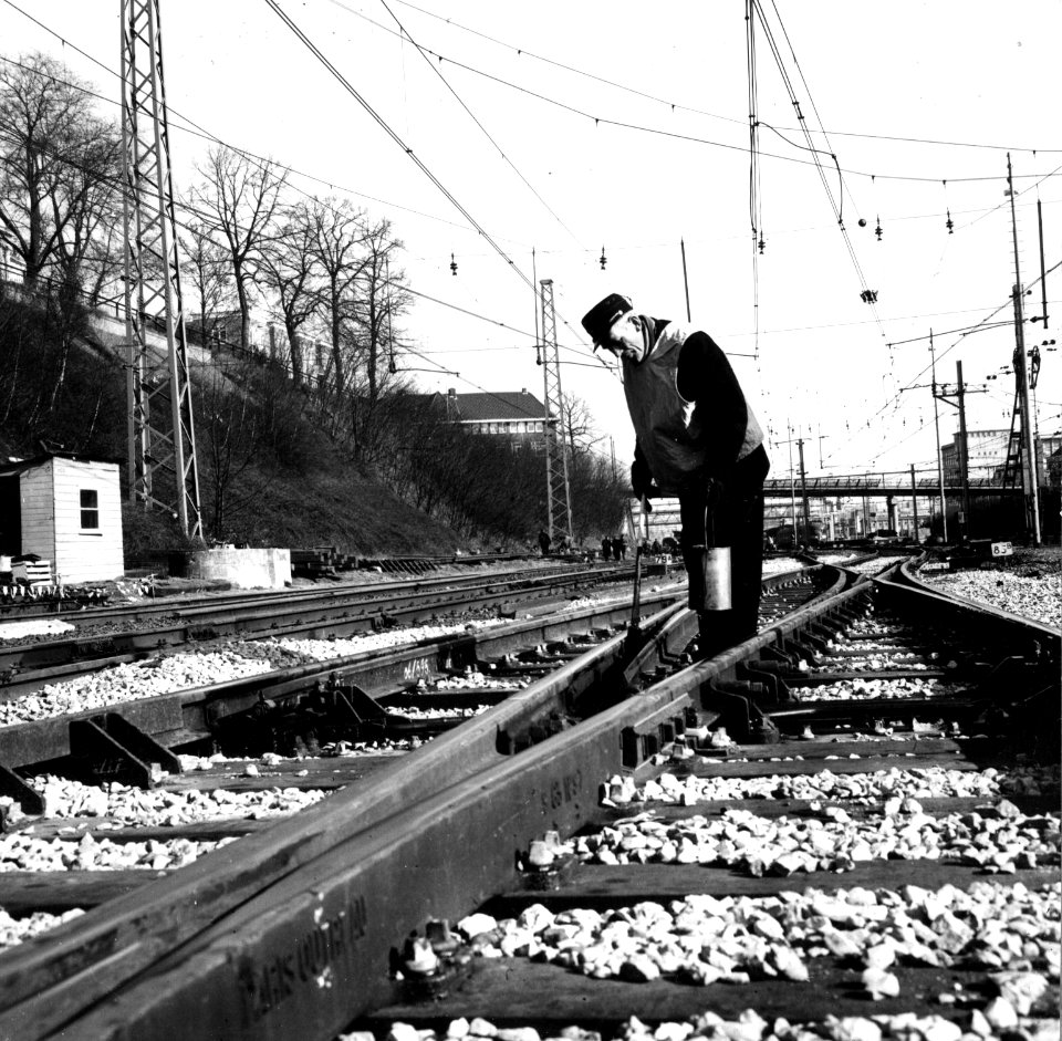 HUA-153403-Afbeelding van een wegwerker van NS tijdens het smeren van een wissel op het emplacement van het NS station Arnhem te Arnhem
