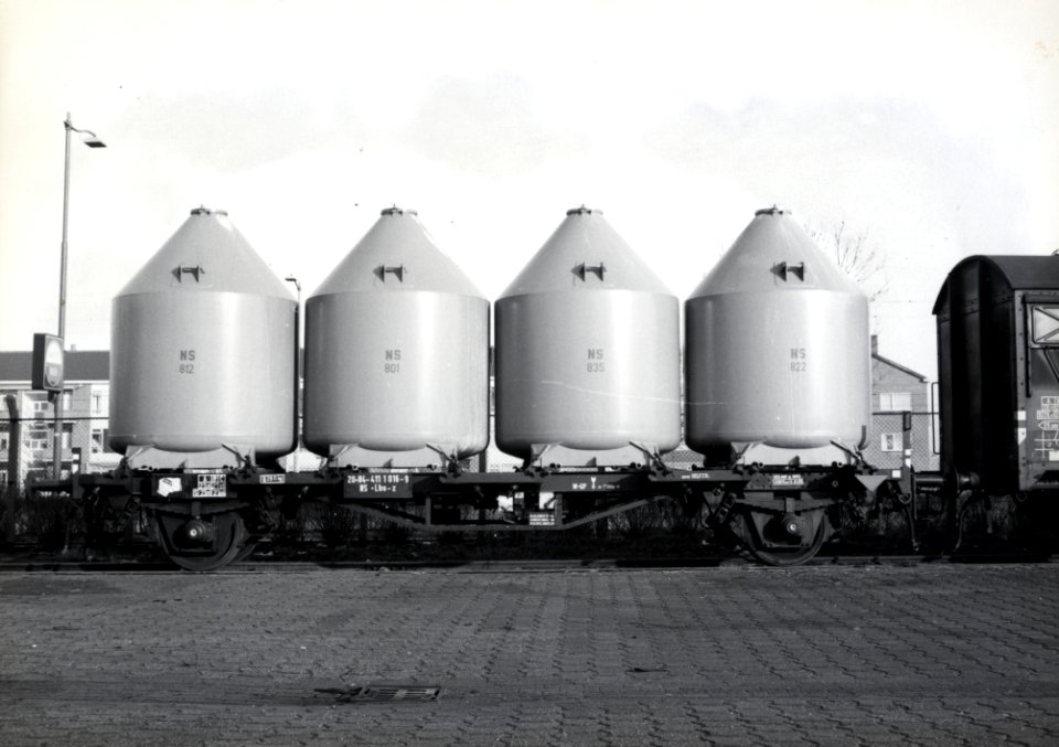 HUA-169591-Afbeelding van een platte wagen van de NS type Lbs z met silolaadkisten voor het vervoer van soda op de laad en losplaats van het NS station Schiedam