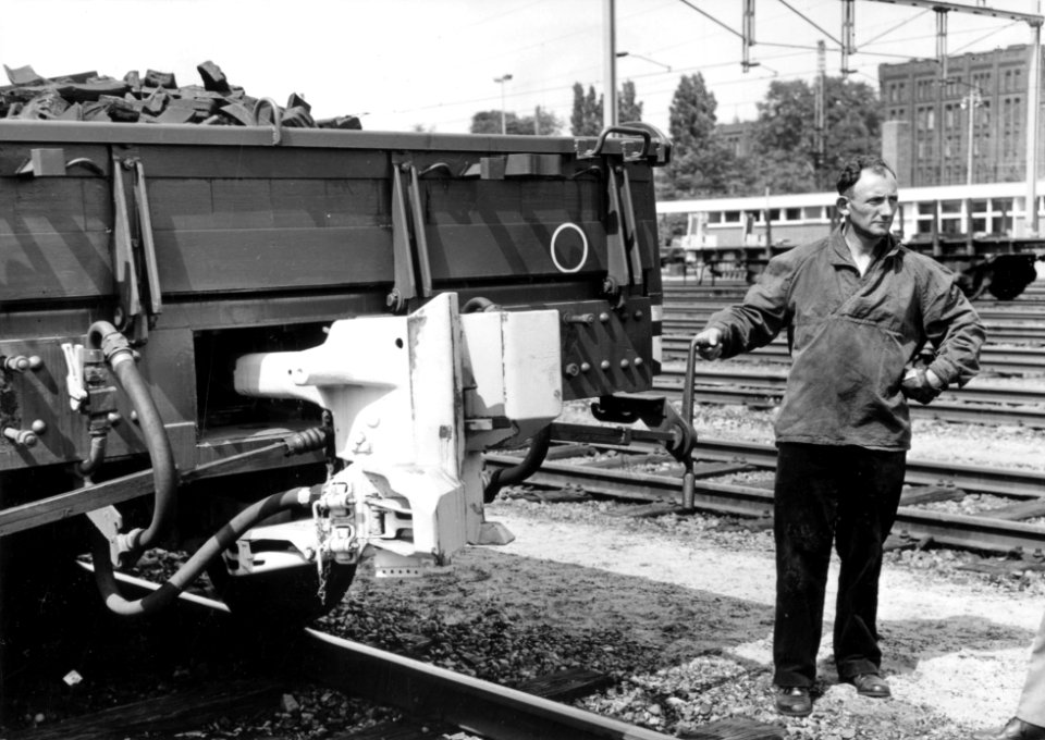 HUA-169512-Afbeelding van een rangeerder van de N.S. bij een proeftrein met goederenwagens voorzien van een automatische koppeling te Utrecht
