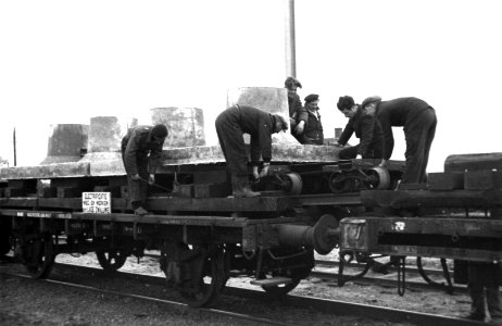 HUA-164316-Afbeelding van het voor transport gereedmaken van betonnen funderingsblokken voor bovenleidingsmasten gefabriceerd op het emplacement van het NS stati
