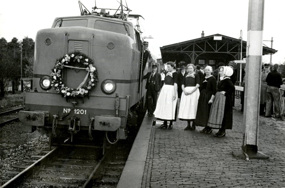 HUA-167872-Afbeelding van de feesttrein ter gelegenheid van de electrificatie van de spoorlijn Amersfoort - Zwolle langs het perron van het N.S.-station Nunspeet te Nunspeet, met de met een bloemenkrans versierd