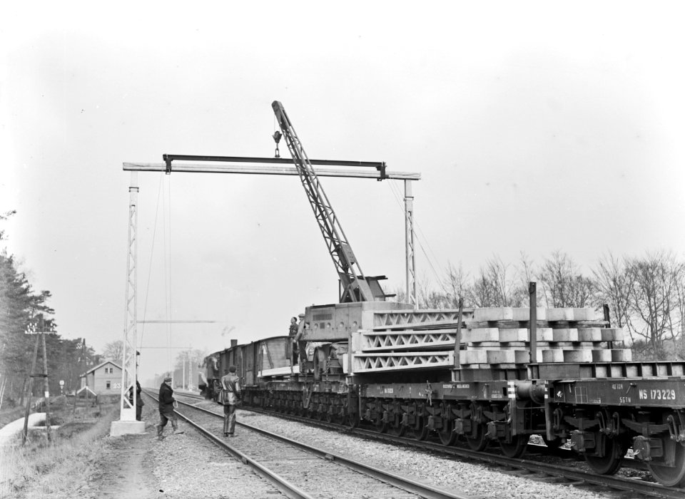 HUA-166418-Afbeelding van het plaatsen van een (betonnen) bovenleidingsportaal ten behoeve van de electrificatie van de spoorlijn Arnhem - Zwolle ter hoogte van Gorssel. Links op de achtergrond wachtpost nr. 23