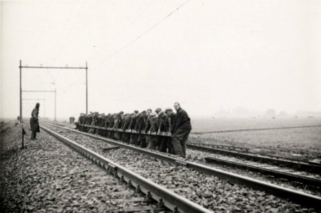 HUA-165753-Afbeelding van de werkzaamheden ten behoeve van de baanverzwaring tussen Amsterdam en Utrecht, ter hoogte van Duivendrecht, met een ploeg wegwerkers die een spoorstaaf verplaatsen