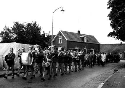 HUA-165603-Afbeelding van een muziekkorps met in hun gevolg de genodigden voor de feestelijke opening van het nieuwe gebouw van het N.S.-station Wehl te Wehl