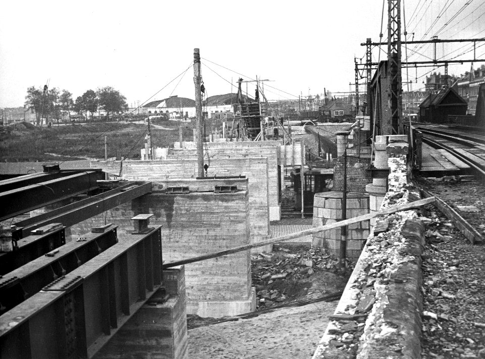 HUA-164281-Gezicht op de herstelwerkzaamheden aan het tijdens de oorlog beschadigde spoorviaduct over de Schiekade te Rotterdam. Op de achtergrond het N.S.-station Rotterdam D.P