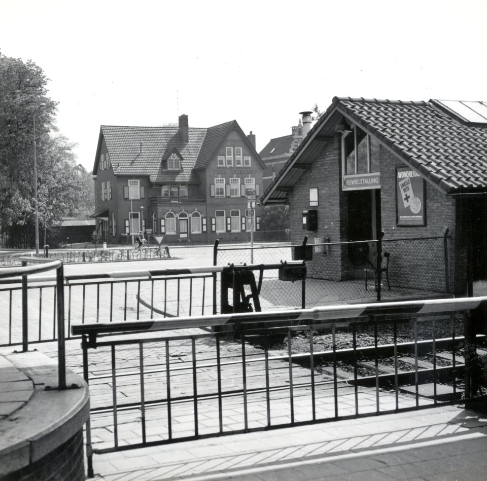 HUA-169391-Gezicht op het overwegpad voor de toegang naar het perron van het N.S.-station Dieren-Doesburg te Dieren, met rechts de rijwielstalling. Op de achtergrond de villa Welgelegen (Stationsplein 10). N.B. 
