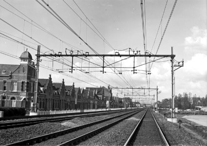 HUA-166442-Gezicht op de spoorbaan met bovenleidingsportalen ten zuiden van het N.S.-station Roosendaal te Roosendaal, kort na de electrificatie van de spoorlijn richting België