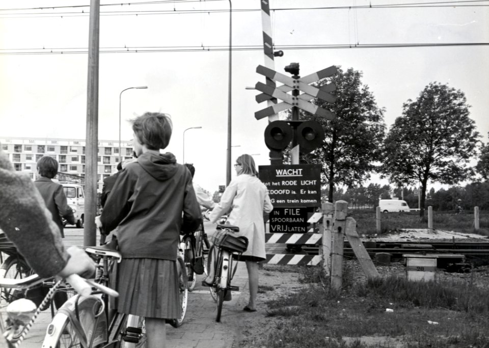 HUA-169424-Afbeelding van enkele wachtende fietsers bij de spoorwegovergang in de Eykmanlaan te Utrecht
