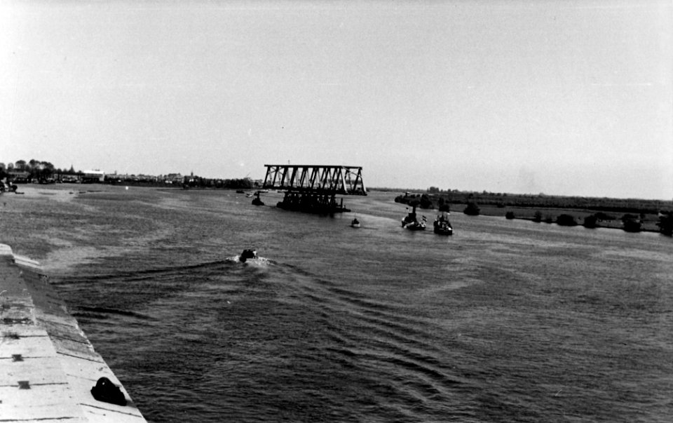 HUA-164390-Afbeelding van het transport van een een brugdeel, bestemd voor de spoorbrug over het Hollands Diep bij Moerdijk, van Dordrecht naar Moerdijk, na het passeren van de spoorbrug over de Beneden Merwede 
