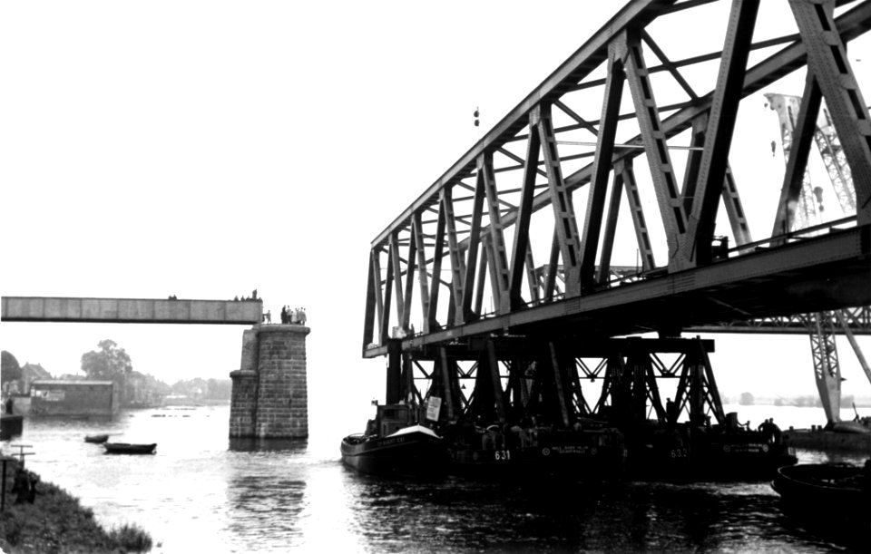 HUA-164376-Afbeelding van het transport van een brugdeel, bestemd voor de spoorbrug over het Hollands Diep bij Moerdijk, ter hoogte van de spoorbrug over de Beneden Merwede bij Baanhoek, waartoe een deel van de 