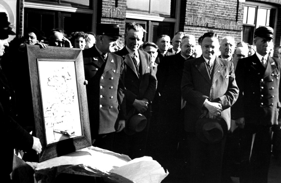 HUA-164365-Afbeelding van de aanbieding van een tegeltableau ter gelegenheid van de opening van de D.E.-dienst Vlissingen-Nijmegen op het perron van het N.S.-station Ravenstein te Ravenstein