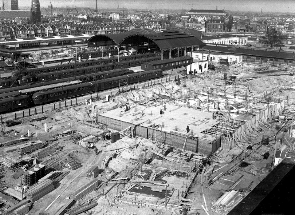 HUA-166186-Gezicht in de bouwput voor het nieuwe N.S.-station Rotterdam C.S. te Rotterdam, met op de achtergrond de perrons en perronkappen (restanten) van het oude station Rotterdam D.P