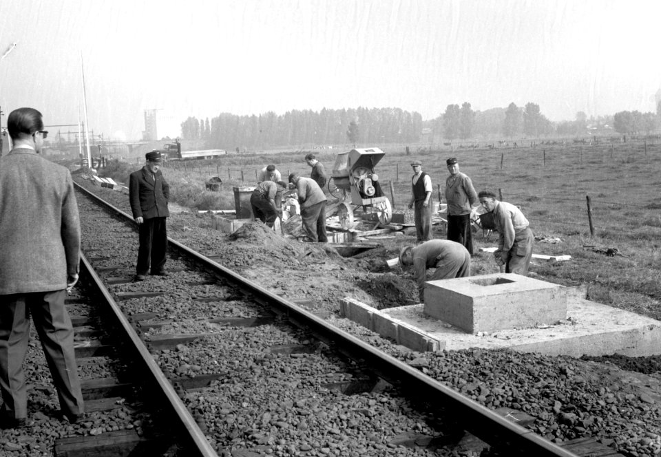 HUA-166444-Afbeelding van het storten van betonnen voeten voor bovenleidingsmasten langs de spoorlijn tussen Roosendaal en essen in verband met de electrificatie van het baanvak