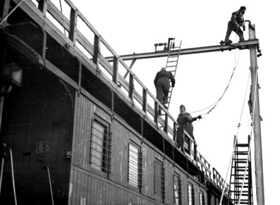 HUA-164369-Afbeelding van monteurs op een bovenleidingsmontagewagen van de N.S. ten zuiden van Brummen tijdens de werkzaamheden ten behoeve van de electrificatie van de spoorlijn Arnhem-Zwolle