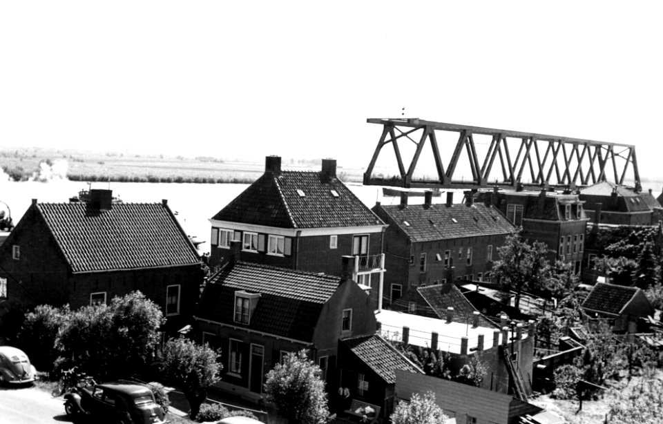 HUA-164388-Afbeelding van het transport van een een brugdeel, bestemd voor de spoorbrug over het Hollands Diep bij Moerdijk, van Dordrecht naar Moerdijk, tijdens het passeren van de spoorbrug over de Beneden Mer