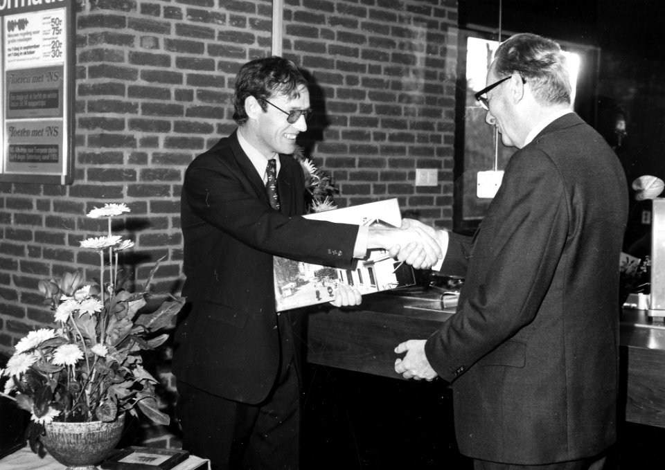 HUA-165517-Afbeelding van de opening van het nieuwe gebouw van het N.S.-station Buitenpost te Buitenpost, met links notaris mr. G. Slobbe die namens het Plaatselijk Belang een foto van het inmiddels afgebroken, 