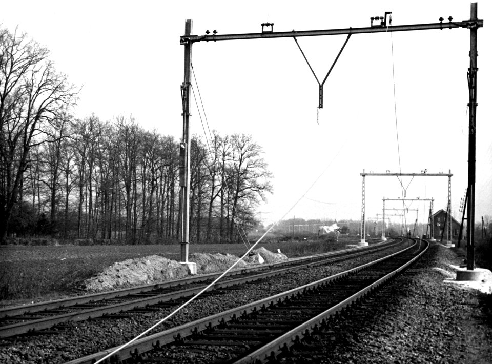 HUA-164368-Gezicht op de spoorlijn ten zuiden van Brummen tijdens de electrificatie, met rechts op de achtergrond wachtpost 10A