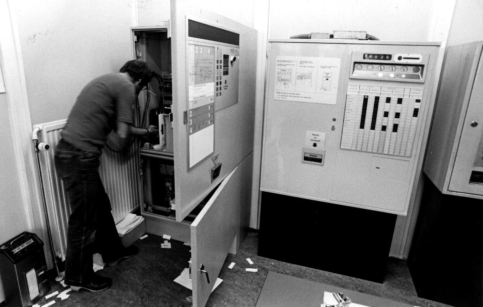 HUA-153360-Afbeelding van een monteur van het seinwezen te Utrecht tijdens werkzaamheden aan een kaartjesautomaat