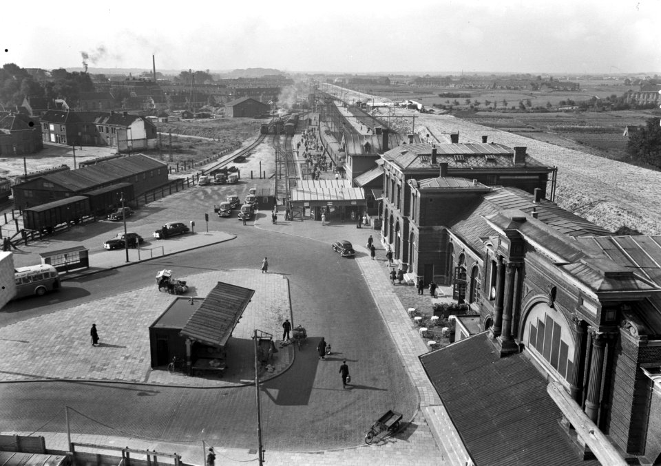 HUA-166185-Gezicht op het Stationsplein bij het N.S.-station Leiden te Leiden, met rechts op de achtergrond de grondwerkzaamheden ten behoeve van de verhoging van de spoorbaan