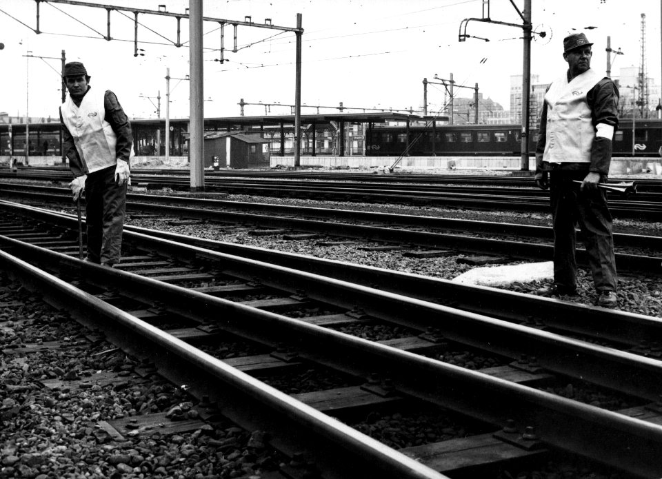 HUA-153418-Afbeelding van een wegwerker en een veiligheidsman op het emplacement van het N.S.-station Utrecht C.S. te Utrecht