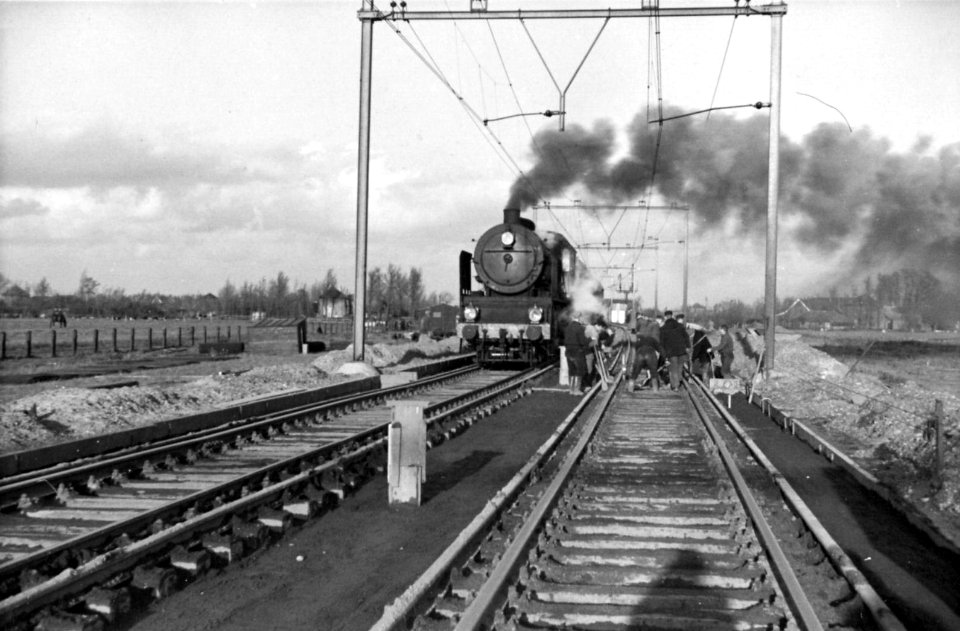 HUA-164306-Afbeelding van de werkzaamheden ten behoeve van de baanverzwaring ter hoogte van Oudewater met een passerende stoomlocomotief