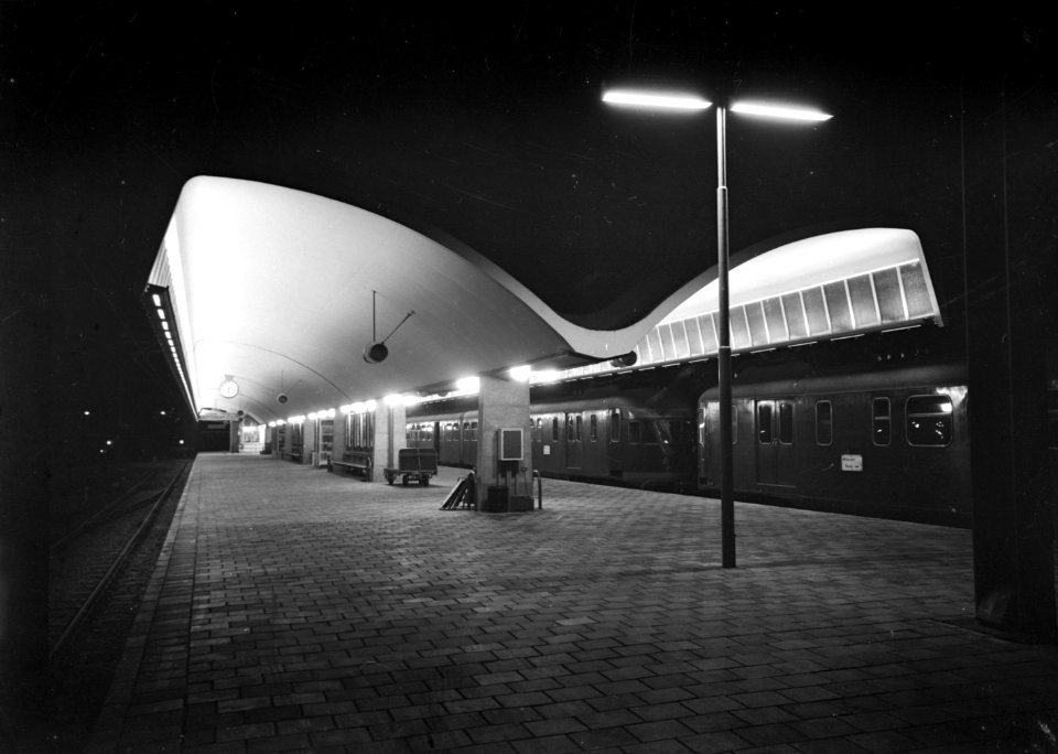 HUA-153220-Gezicht op een perron van het N.S.-station Rotterdam C.S. te Rotterdam met rechts enkele treinstellen mat. 1946 van de N.S. bij avond
