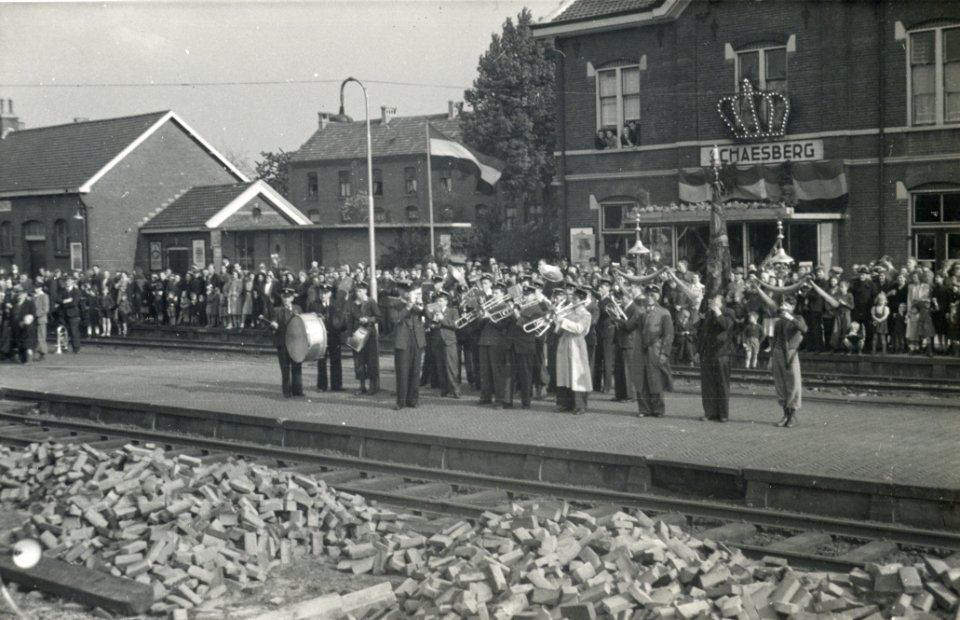 HUA-164335-Afbeelding van een blaaskapel op het perron van het versierde N.S.-station Schaesberg te Schaesberg tijdens de feestelijkheden ter gelegenheid van de electrificatie van de spoorlijnen in Zuid-Limburg 