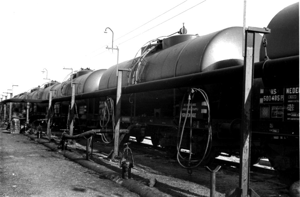 HUA-164322-Afbeelding van ketelwagens met ruwe aardolie bij het overlaadstation van een olieraffinaderij te Pernis