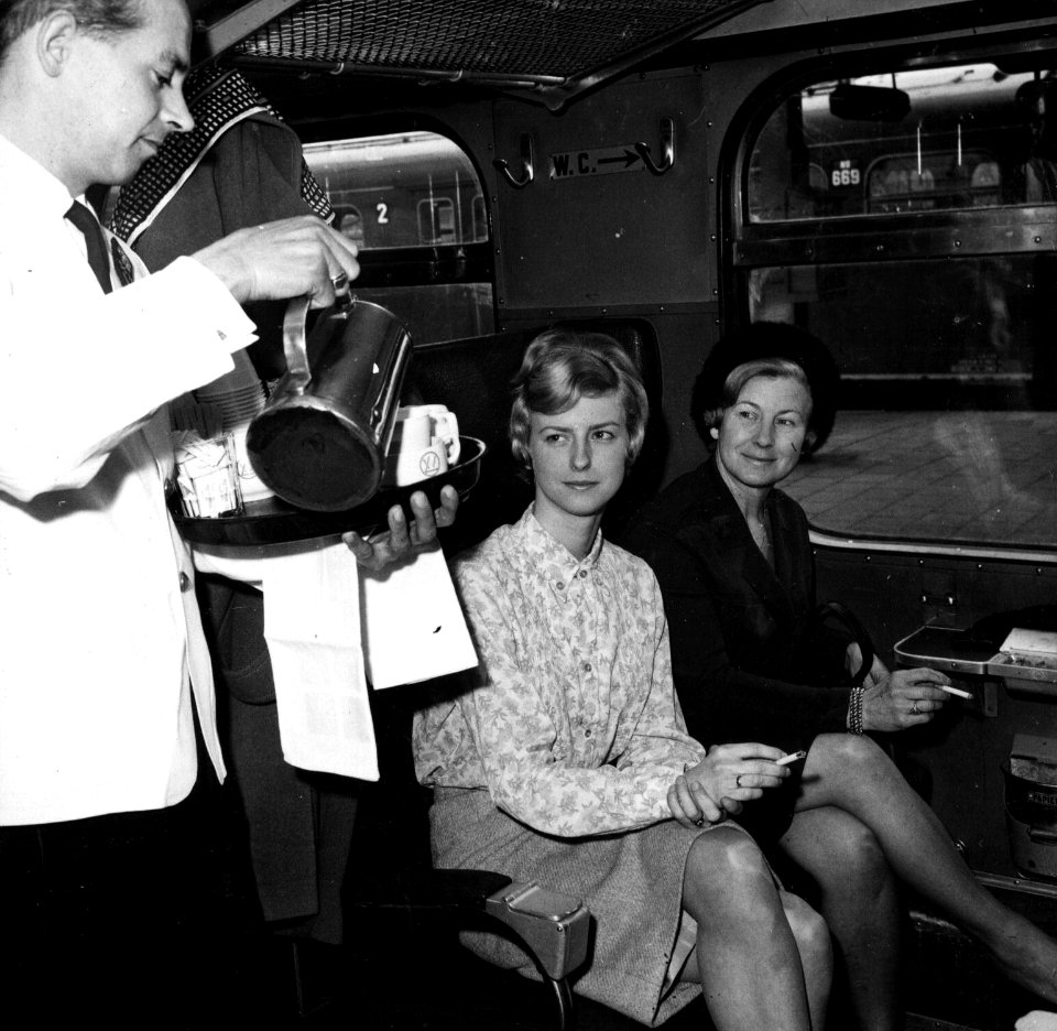 HUA-152871-Afbeelding van twee dames in een trein van de N.S., met links een steward van Wagons-Lits die koffie serveert