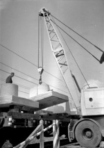 HUA-166433-Afbeelding van het beladen van wagens met betonnen voeten voor bovenleidingsmasten bij het Spoorwegbouwbedrijf te Maarssen