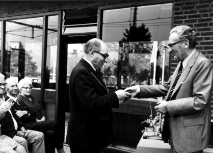 HUA-165503-Afbeelding van de opening van het nieuwe gebouw van het N.S.-station Akkrum te Akkrum, met rechts J.A. Muetstege (chef van het districtsbureau Noord-Oost van de N.S.) die burgemeester J. Anker van Uti