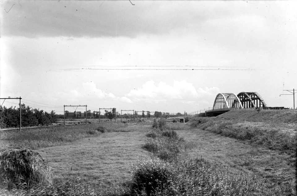 HUA-153578-Gezicht op het oude, lage tracé van de spoorlijn Utrecht-Geldermalsen bij Schalkwijk met rechts het nieuwe, hoge tracé met verkeers- en spoorbrug over het nog te graven Amsterdam-Rijnkanaal
