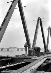 HUA-152693-Afbeelding van de bouw van een nieuw brugdeel voor de spoorbrug over het Hollands Diep bij Moerdijk. Op de achtergrond de oude brug met tijdelijke overspanningen