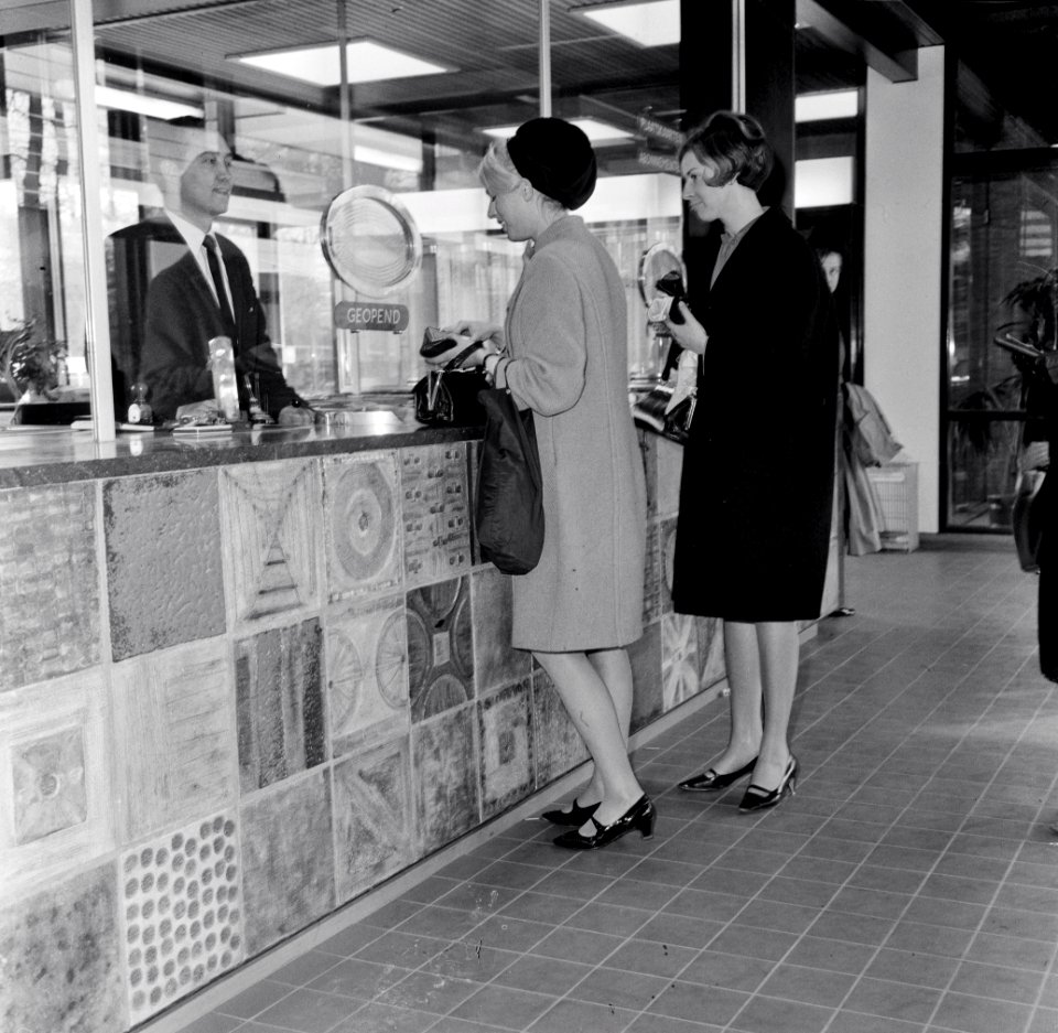 HUA-152415-Interieur van het N.S.-station Driebergen-Zeist te Driebergen-Rijsenburg- loketbalie, met enkele dames bij het loket